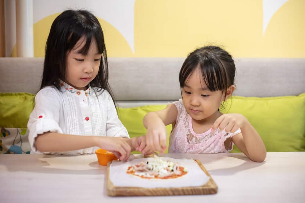 Asian Little Chinese Girls DIY mini pizza at home