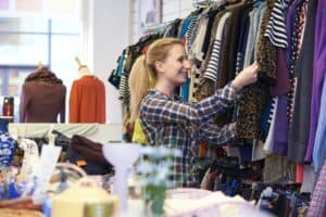 Female shopper in thrift store looking at clothes.